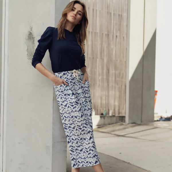 a woman in a blue top with a long skirt